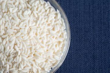 A top down view of a glass bowl of sticky rice, cut off on the left side of the frame.