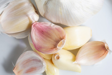 A top down view of a garlic cloves and bulbs on a plate.