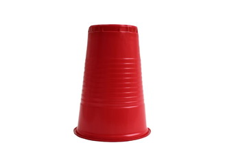 Red plastic cup stands upside down on a white background