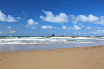 Fototapeta na wymiar Seascape. Blue sky with white clouds. Surf. Golden sand.