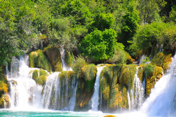 A picturesque cascade waterfall among large stones in the Krka Landscape Park, Croatia in spring or summer. The best big beautiful Croatian waterfalls, mountains and nature.