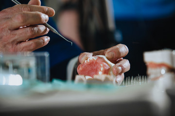 A dental technician processes a cast of the jaw.