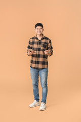 Fototapeta premium Asian man with credit card and tablet computer on color background