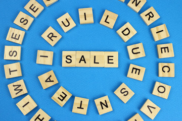 word sale made of wooden letters on a blue background