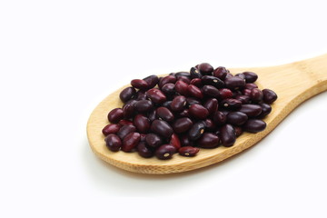 Wooden spoon with red beans lies on a white background
