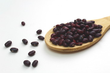 Wooden spoon with red beans lies on a white background