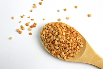 Wooden spoon with small peas on a white background