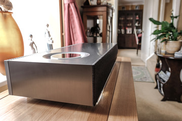 Newly installed luxury hi-res music streamer and smart speaker on a purpose built cabinet. Seen in the interior of a large house with traditional decor.