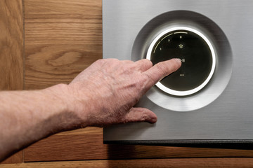  Owner seen touching the play icon on a luxury hi-res music streamer and smart speaker. The OLED...