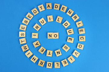 The word no is made of wooden letters on a blue background