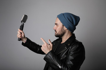 Young man blogger recording broadcast, making fun and using smartphone. Isolated.
