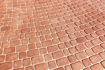 Top view on red paving stone road. Old pavement of granite texture. Street cobblestone sidewalk....