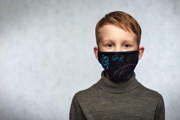 A worried child wearing a protective face mask to prevent  infection or pollution. COVID-19...