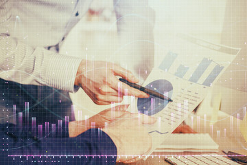 Financial trading graph double exposure with man desktop background.