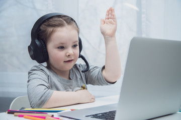 Naklejka premium Cute little girl smiling and looking at laptop, Little girl using laptop