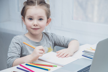 Cute little girl smiling and looking at laptop, Little girl using laptop