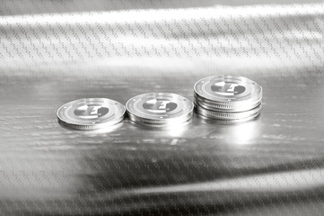 Litecoin (LTC) digital crypto currency. Stack of silver coins against the background of numbers. Cyber money. - 334964541