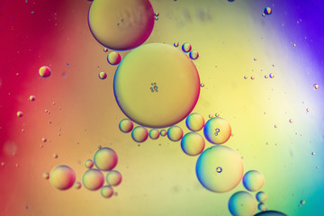 Fototapeta na wymiar Oil drops in water. Abstract defocused psychedelic pattern image rainbow colored. Abstract background with colorful gradient colors. DOF.