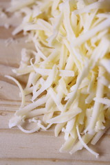 Grated cheese on wooden chopping board
