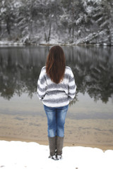 vertical photo of a beautiful long-haired brunette on a background of a winter river