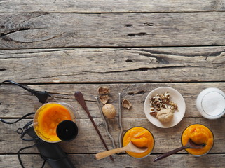 Health benefits of pumpkin. Pumpkin pulp is passed through a blender. Natural smoothie made at home on a natural wooden table. Place for text.Top view.