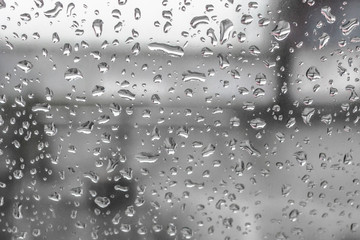 Spring rain. May thunderstorm. Raindrops on the glass. The texture of the drops. Wet window. Chill day. Inclement weather. Torrential rain. View of the world from the window.