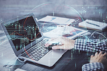 Double exposure of forex chart with man working on computer on background. Concept of market analysis.