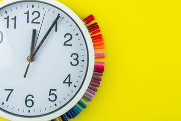 The watch and palette of colors for manicureons on tips stands under the clock all standing on a...
