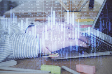 Multi exposure of stock market graph with man working on laptop on background. Concept of financial analysis.