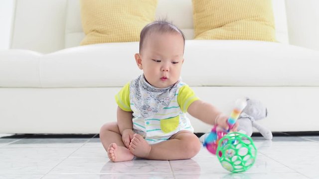 Little asian boy sitting on the floor and playing toys.