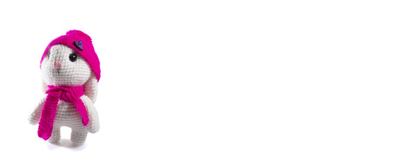 Cute handmade white rabbit in a pink hat wishes you a happy Easter! Isolated on a white background, frame for text, banner