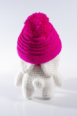 Cute handmade white rabbit in a pink hat wishes you a happy Easter! White background, background, rear view, close up