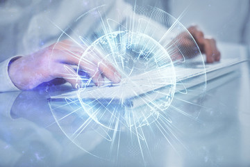 Double exposure of businessman working on laptop on background. International business hologram in front. Concept of success.
