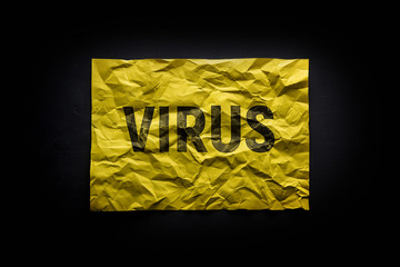 The word virus on crumpled paper. A warning of danger.