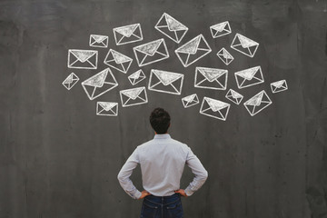 email marketing or newsletter concept, online communication, business man looking at many e-mails...