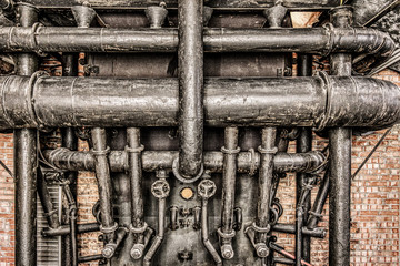 HDR pipes from an old abandoned factory. Brick wall, rust and dust