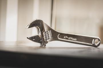 Wrench, French key, on a wooden table