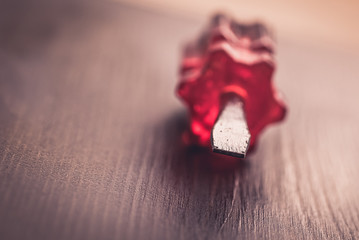 Small screwdriver with red handle isolated on wooden background