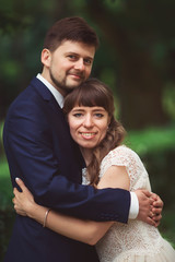 Naklejka premium Bride and groom in a park .Couple newlyweds bride and groom at a wedding in nature green