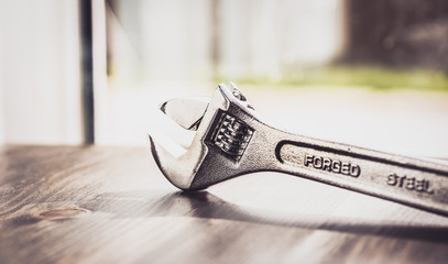 French key, wrench, made with forged steel isolated on wooden worktop