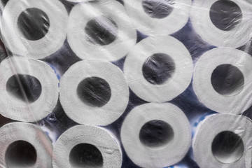 Rolls of toilet paper, packed in cellophane film, background