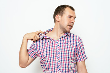 Closeup portrait of young man opening shirt to vent,it's hot. Negative emotion, facial expression, feeling