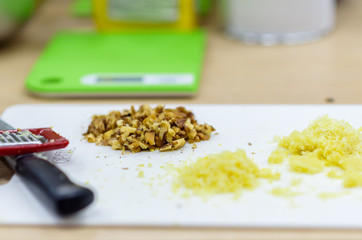 Grated walnuts and cheese lying on a cutting board.
