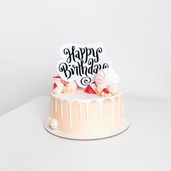 Beautiful pink birthday cake for a girl decorated with sweet candies with white background