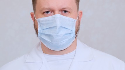 sad and upset Male in a protective mask and a white shirt looks at the camera, close-up. Hygiene concept. prevent the spread of germs and bacteria and avoid infection with the crown virus. copy space