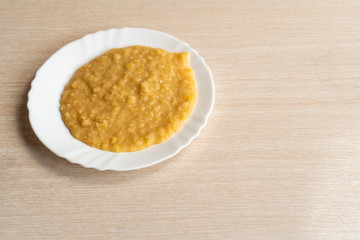 Yellow pea puree in a white plate