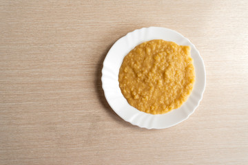 Yellow pea puree in a white plate