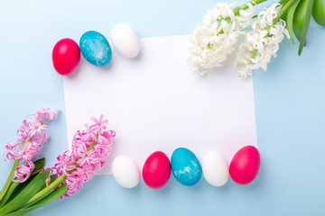 Naklejka na ściany i meble Spring mockup with Easter eggs, hyacinths and blank of white paper on blue background. Easter concept. Copy space. Top view