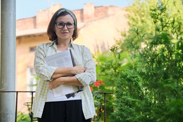 Mature woman standing on open balcony in isolation,