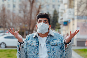 A fashionably dressed young Indian man in a medical mask walks on the street during the 2019-nCoV pandemic. hygienic mask to prevent infection, airborne respiratory illness such as flu